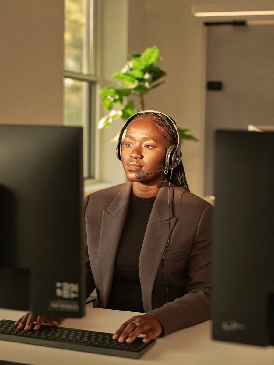 A Nairobi Desk team member working at her desk with a headset